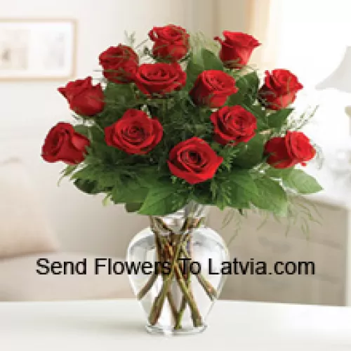 11 trandafiri roșii cu câțiva ferigi într-o vază de sticlă